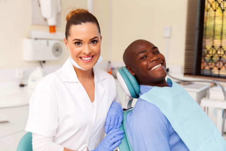 Hygienist with patient sitting in chair